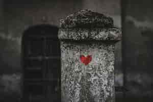 Free photo red heart painted on a gravestone in a cemetery