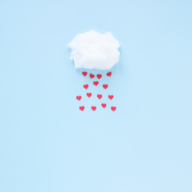 Red hearts falling from cloud 