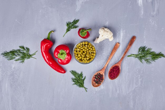 Red hot chilies with peas and spices in wooden spoons.