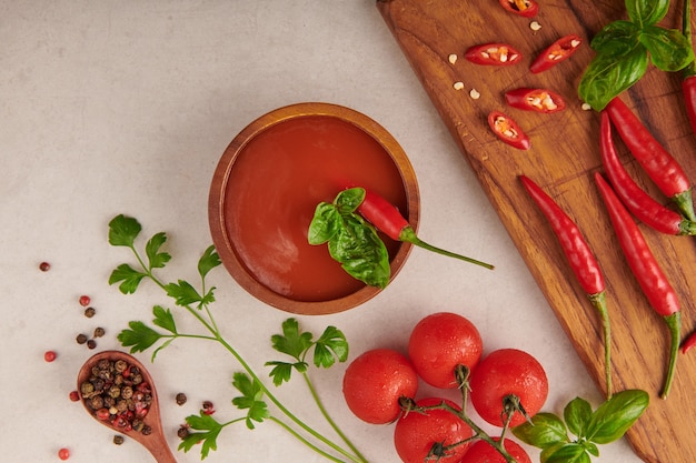 Free Photo red hot chilli sauce. tomato ketchup, chilli sauce, puree with chili pepper, tomatoes and garlic. on wooden cutting board on stone surface. top view.