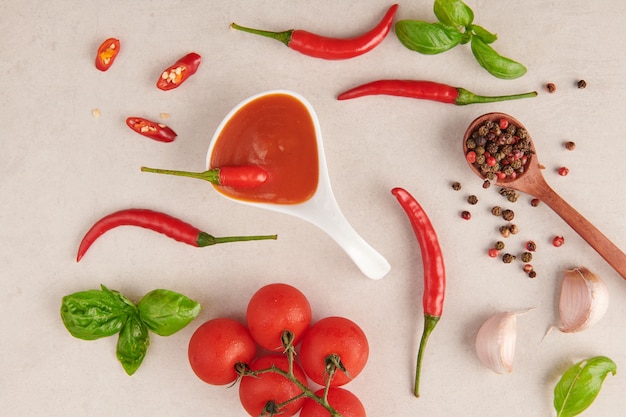 Red hot chilli sauce. tomato ketchup, chilli sauce, puree with chili pepper, Vegetables, tomatoes and garlic. on on stone surface. top view.