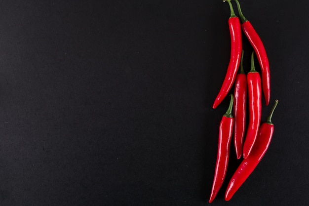 red hot pepper with copy space on black surface top view