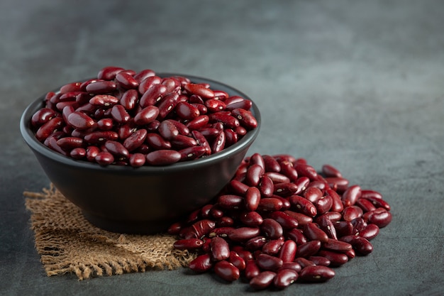 Free photo red kidney beans in black small bowl place on dark floor