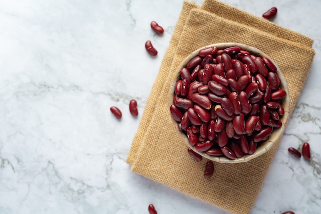 Free photo red kidney beans in a small bowl place on sack fabric