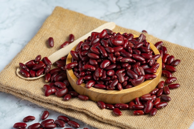 Red kidney beans in a small wooden plate place on sack fabric