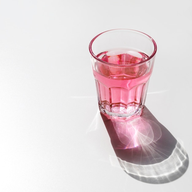 Red liquid glass with shining dark shadow on white background