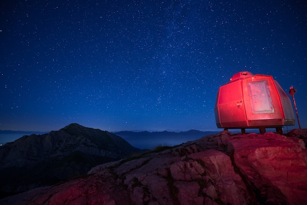 Free Photo red lit bivouac in the tall mountains under a beautiful starry sky