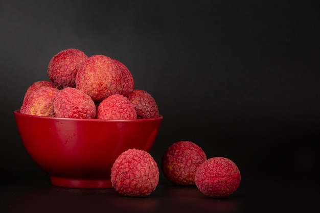 Free Photo red lychee fruit placed in a basket.