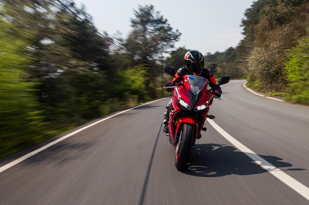 Red motorcycle driving on the road.