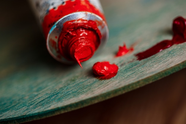 Free Photo red oil paint on palette over wood wall