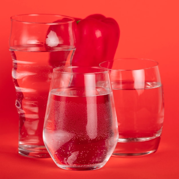 Red pepper surrounded by glasses of water