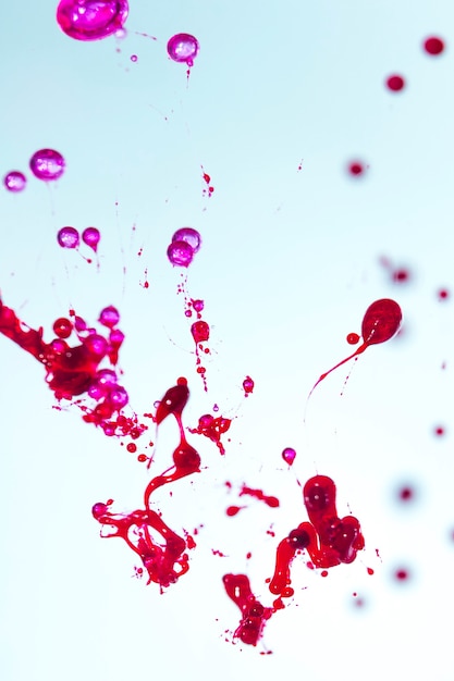 Free photo red and pink splashes on blue background