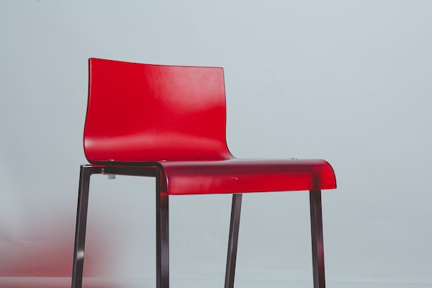 Free photo red plastic chair on white wall