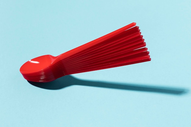 Red plastic spoons in a pile