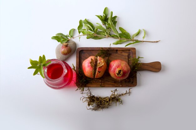 Red pomegranates and sauce in the wooden board