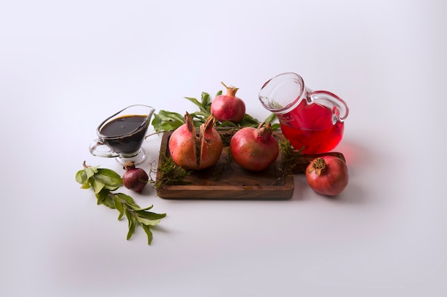 Free Photo red pomegranates and sauce in the wooden board