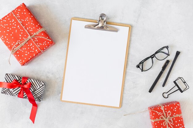 Red present boxes, eyeglasses, clipboard and pens