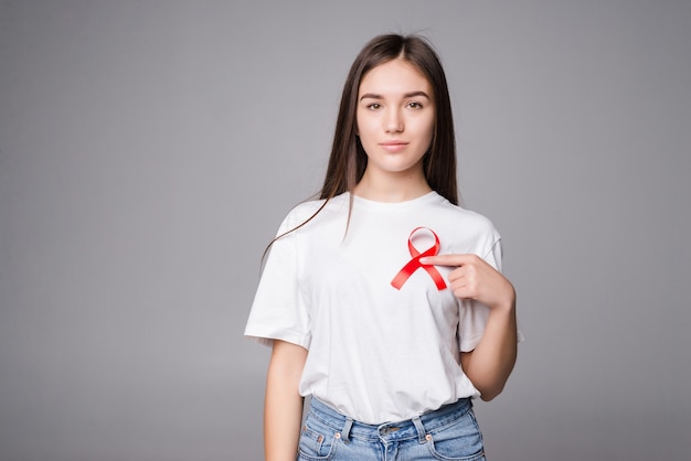 Free photo red ribbon breast cancer of a woman isolated on gray wall