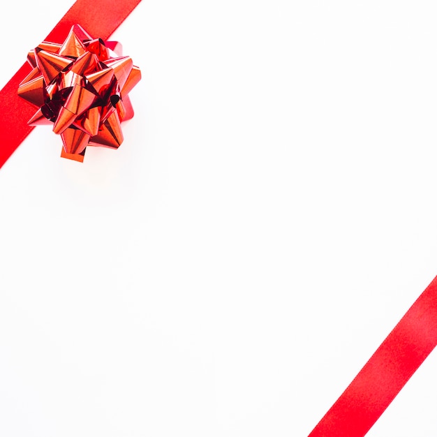 Red ribbon and satin bow on blank white background