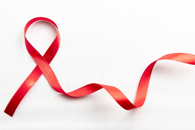 Red ribbon with white background. Hiv Aids ribbon awareness