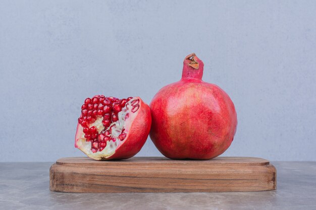 Red ripe pomegranates on wooden board. 