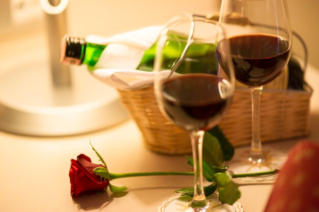 Red rose with two glasses of wine