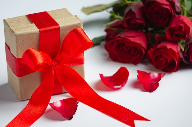 Red roses and gift box on marble background