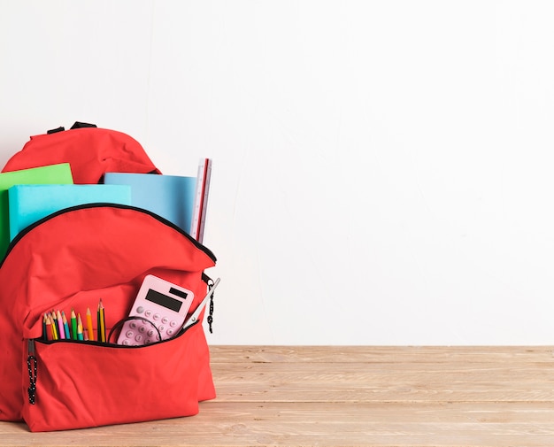 Free Photo red school bag with essential supplies 