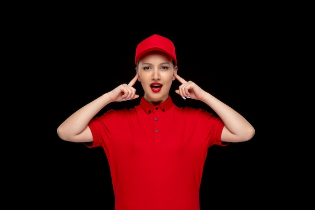 Free photo red shirt day annoyed girl touching temples in a red cap wearing shirt and lipstick