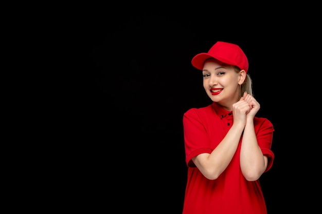 Free photo red shirt day excited girl with holding hands in a red cap wearing shirt and bright lipstick