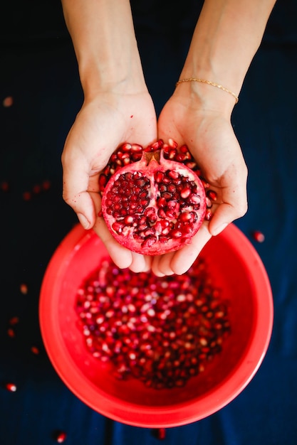 Free photo red sliced pomegranate in hands