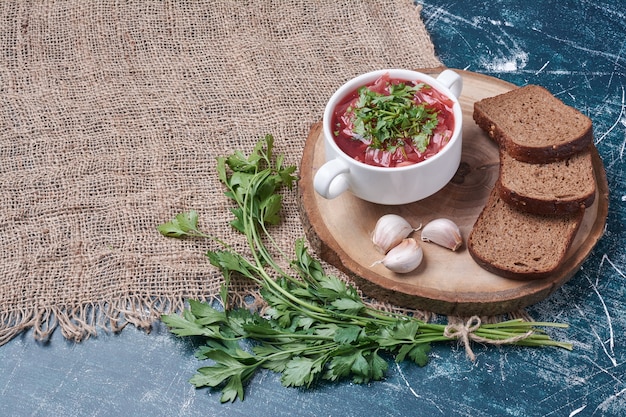 Red soup with herbs and bread slices.