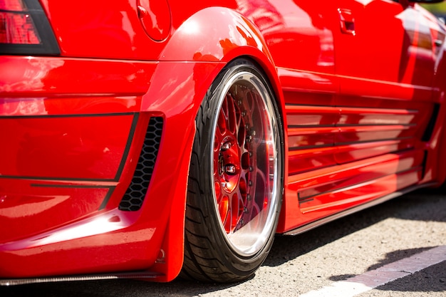 Free photo red sports tuned car rear view of the wheel, close-up