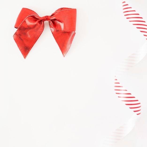 Free Photo red stain bow and striped ribbon on white background