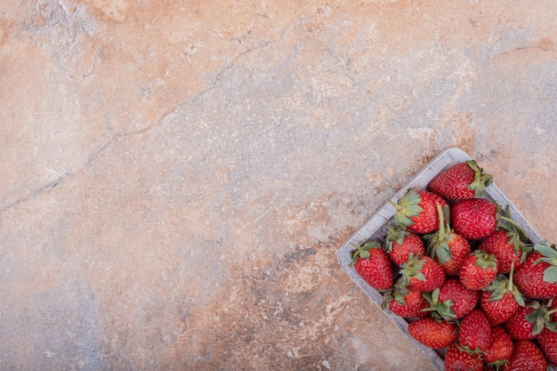 Free photo red strawberries on square rustic platter.