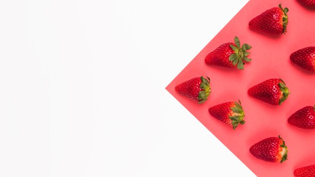 Red tasty strawberries on pink and white multicolored background