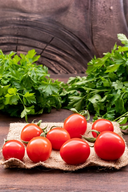 red tomatoes on sacking with parsley wooden