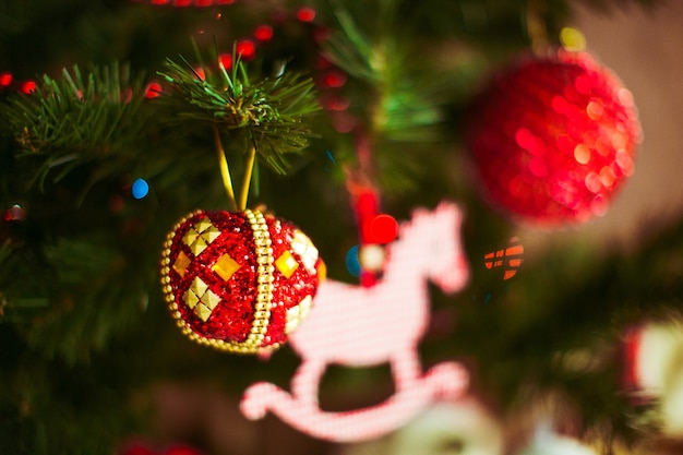 Red toys hang on a Christmas tree 