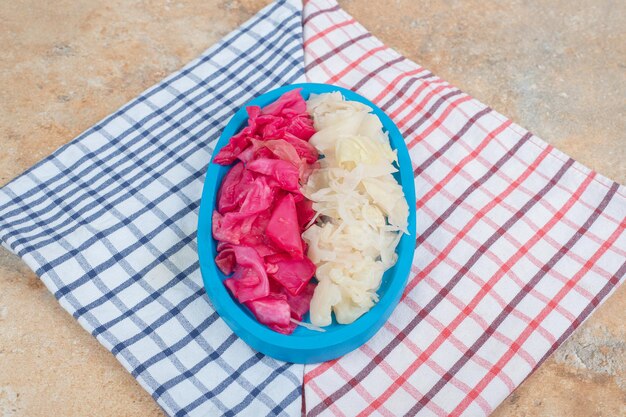 Red and white fermented cabbage on blue plate