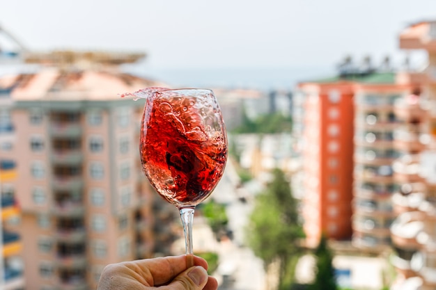 Red wine with ice cubes in a glass on a outside view. side view.