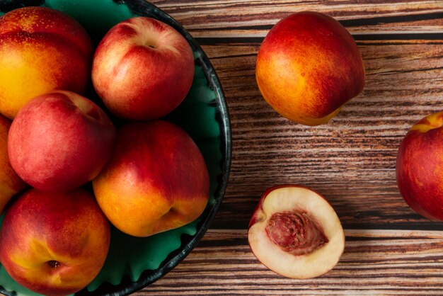 Red and yellow peaches in a green platter