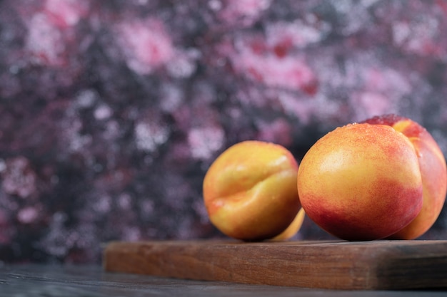 Free photo red yellow peaches isolated on a wooden board.