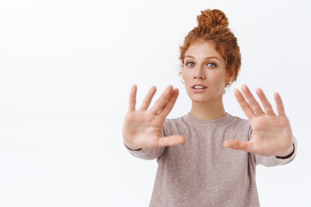 Free photo redhead beautiful woman with curly combed hair, pulling arms forward and gazing at front