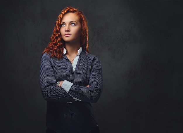 Free Photo redhead female supervisor dressed in an elegant suit over grey background.