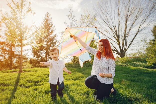 Free photo redhead mom in a white blouse playing with her little sweet son i