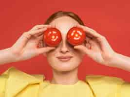 Free photo redhead woman holding tomatoes