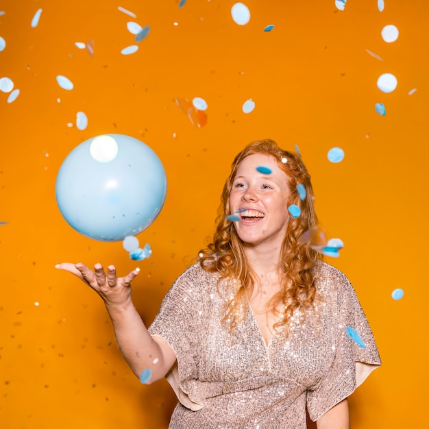 Free photo redhead woman playing with a blue balloon