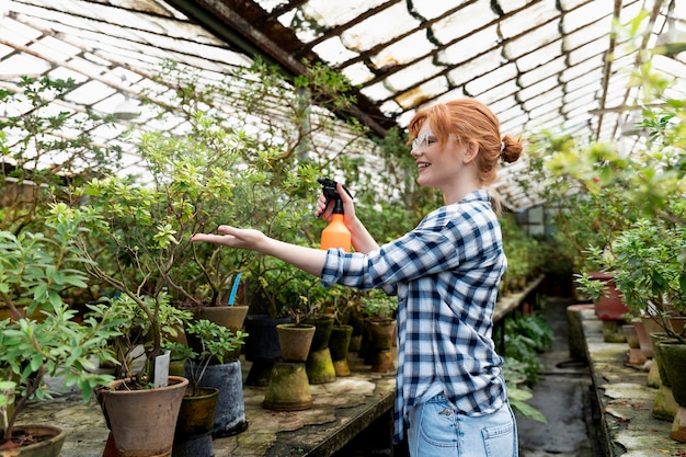 Redhead woman taking care of her plants in a greenhouse