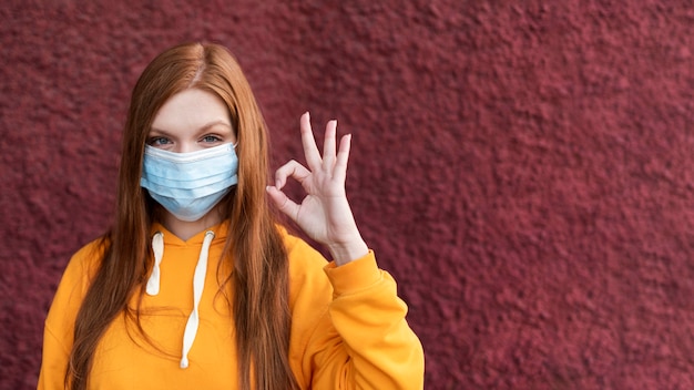 Redhead woman wearing a face mask with copy space