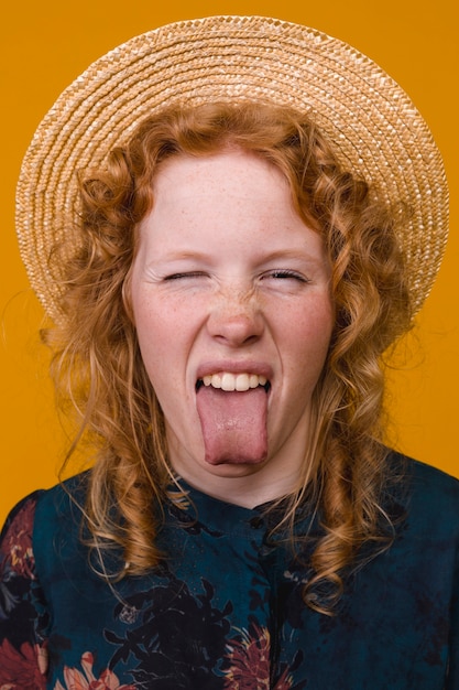 Free photo redhead young freckled woman showing tongue